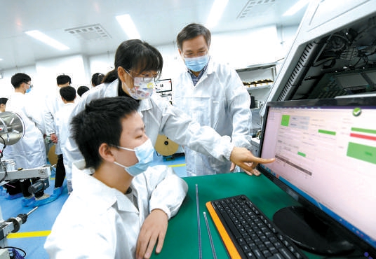 北京电子科技职业学院集成电路封测生产性实训基地内，学生的专业课搬到生产线上，学校老师和企业专家共同给学生上课。